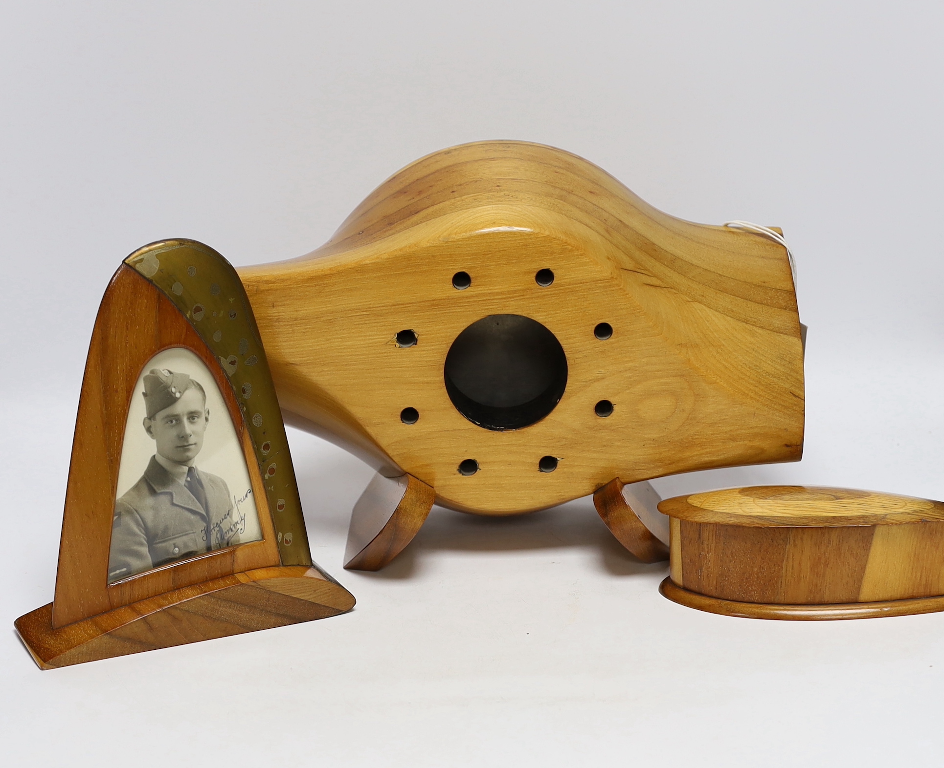 A WWII wooden propeller clock case, reputedly from a Spitfire related photo frame housing a black and white photograph of a soldier together with a trinket box, 35cm wide